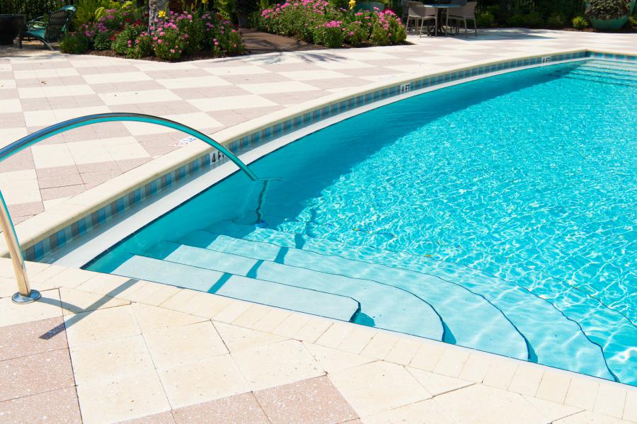 Elevating Backyard Experiences: Integrating Tanning Ledges, Water Features & Slides into Pool Designs